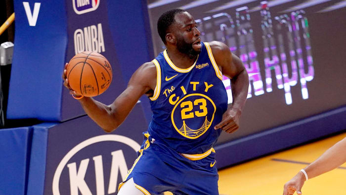 Warriors forward Draymond Green holds a basketball.